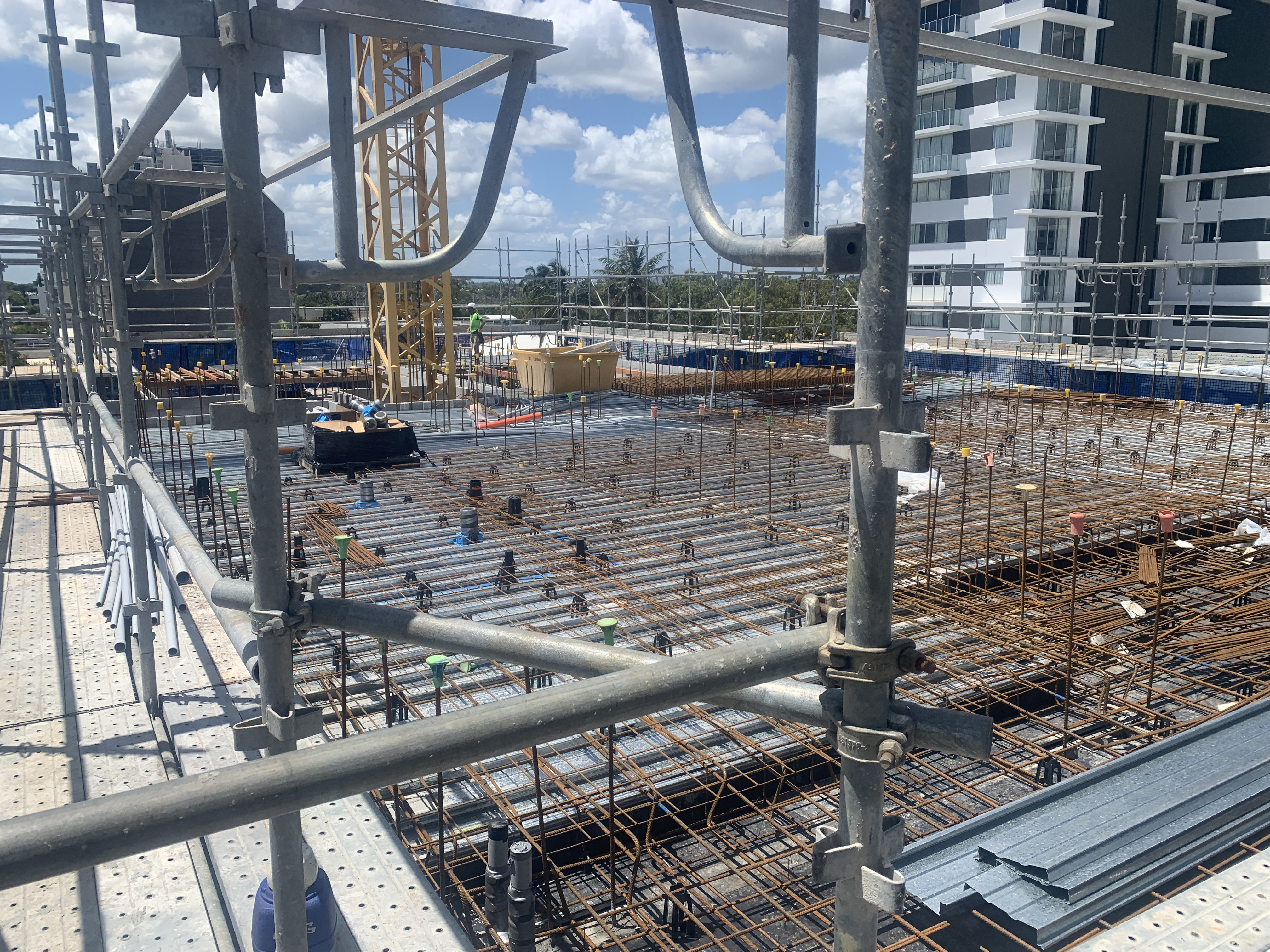 Large commercial high-rise slab preparation — reo mesh grid with crane and apartment towers