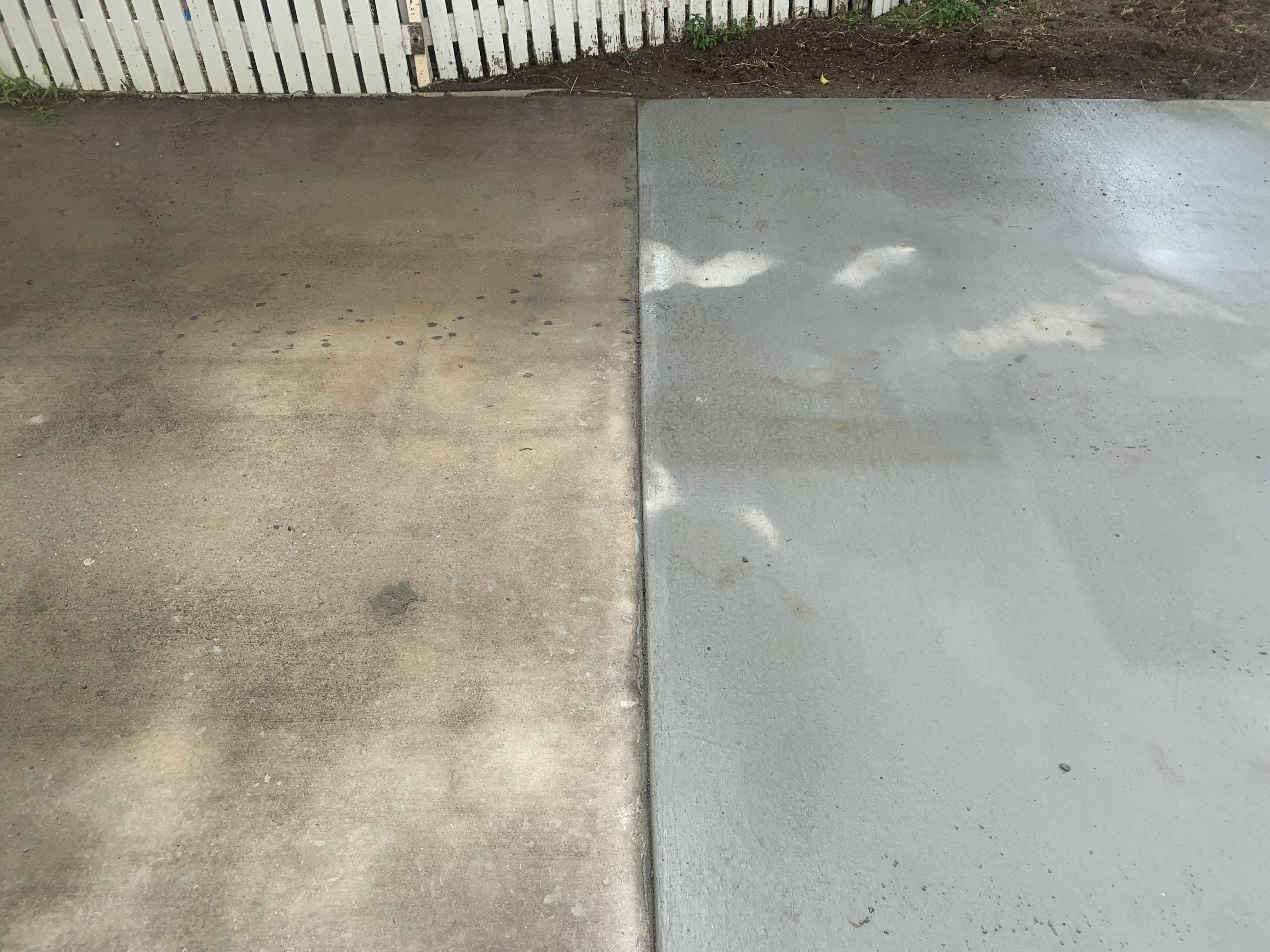 Fresh concrete driveway poured next to old concrete showing before and after