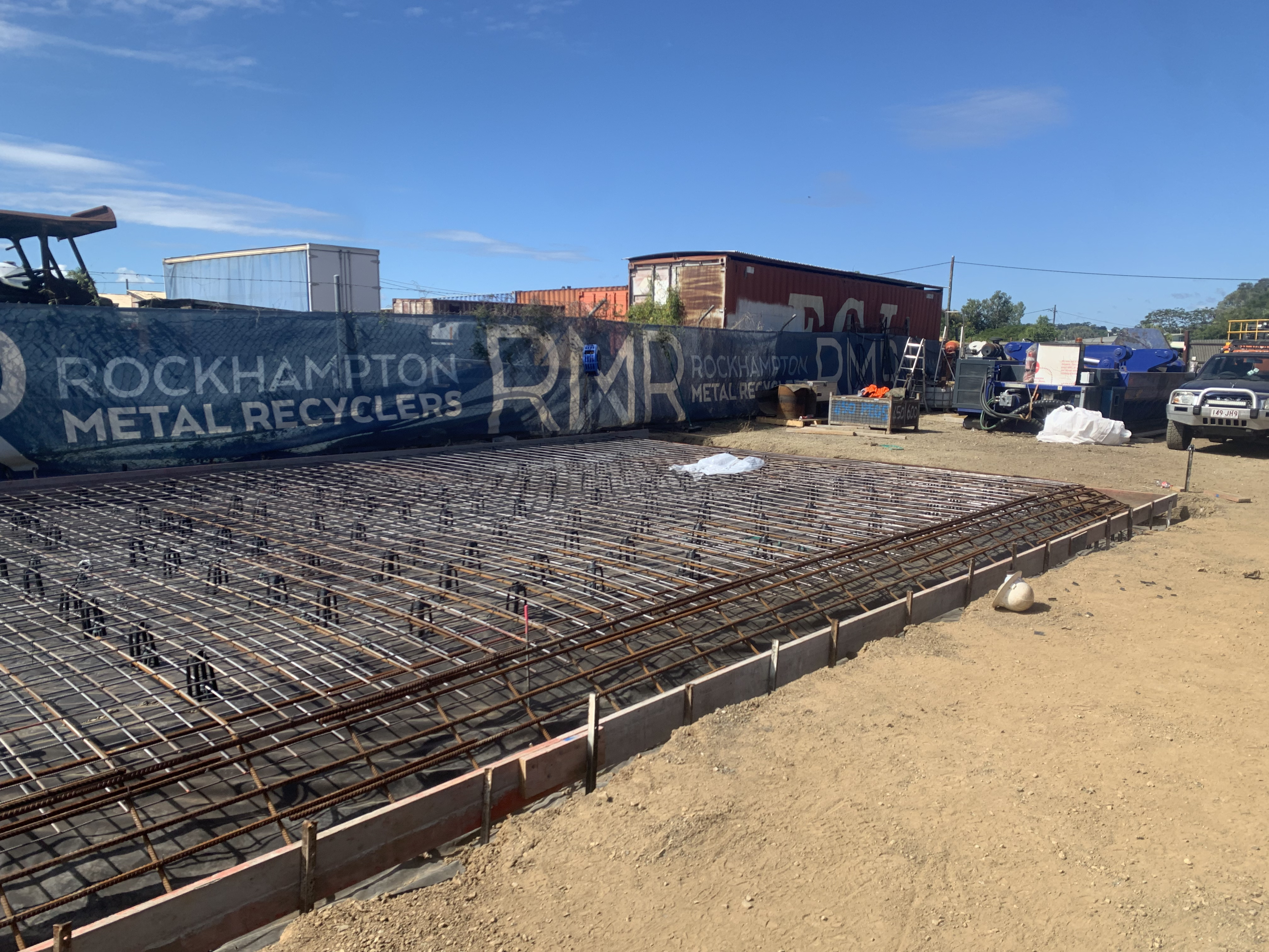 Large commercial concrete slab pre-pour — reo mesh and formwork under clear blue sky