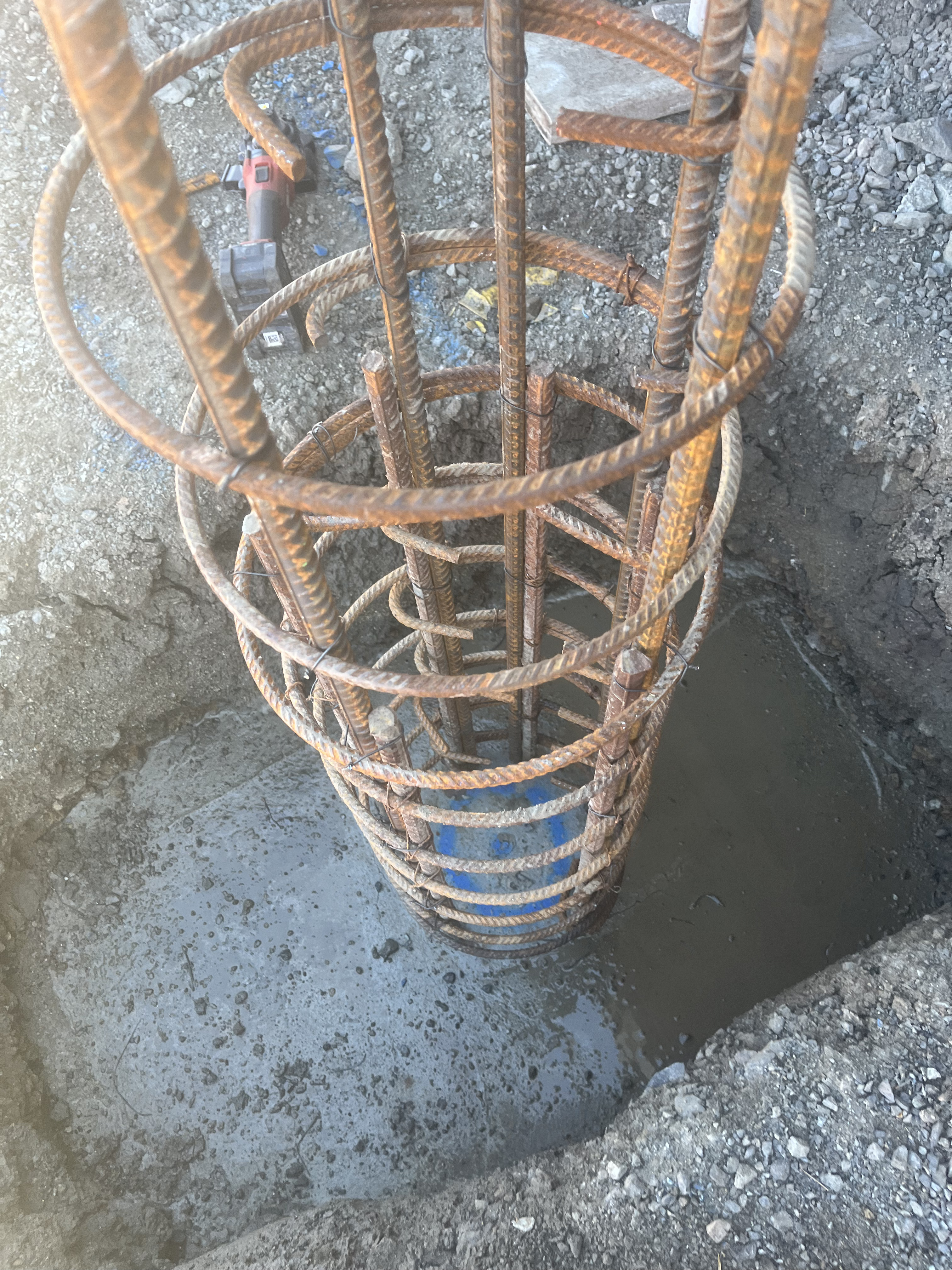 Circular column reo cage in excavated footing hole with water at base
